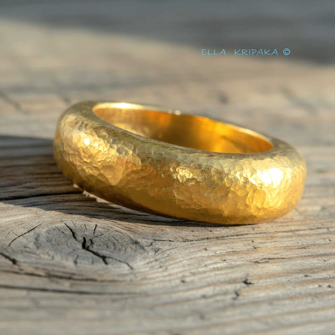 Hammered 24k Gold 9999 gold Ancient Rome  thick ring with textured forged gold on a grey old wooden background, branded artist-jeweler's name 'Ella Kripaka'