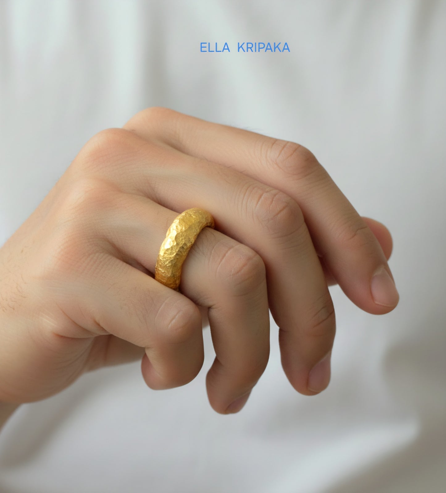 Hammered organic 24k Gold 9999 gold uneven signet thick ring wirn on man's finger and on a white t-shirt background, branded 'Ella Kripaka'