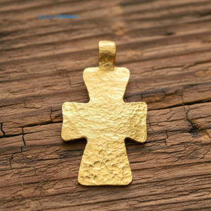 Hammered 24k gold textured cross pendant on rustic old wooden surface, creator artist-jeweler 'Ella Kripaka' branding
