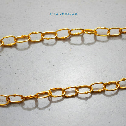 22k gold hammered chain on grey concrete background, artist-jeweler's name 'Ella Kripaka' branding