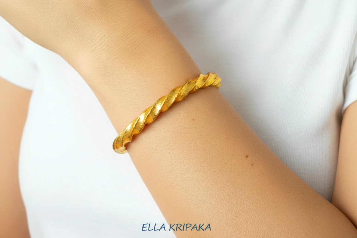 Viking twisted hammered 24k 9999 Gold thick cuff bracelet wirn on wrist by a woman on a white t-shirt background, and with 'Ella Kripaka' branding