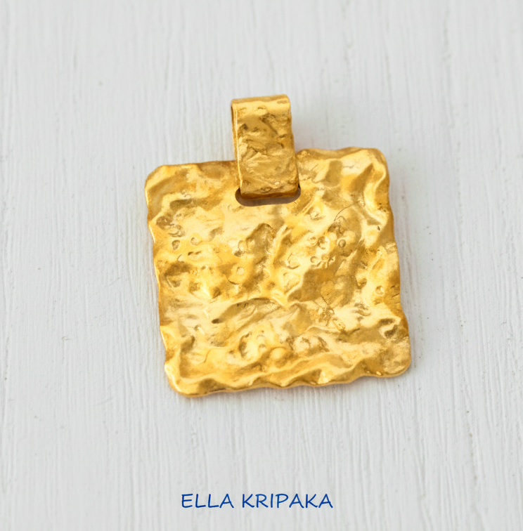 Organic 24k gold wavy textured square pendant hammered with uneven edges on white wooden background, with 'Ella Kripaka' branding