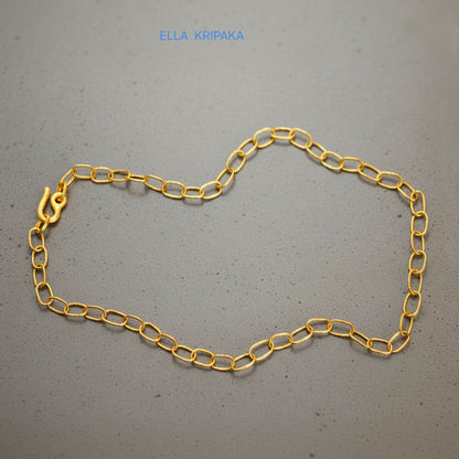 22k gold hammered chain necklace with thick hook clasp on grey concrete background, artist-jeweler's name 'Ella Kripaka' branding