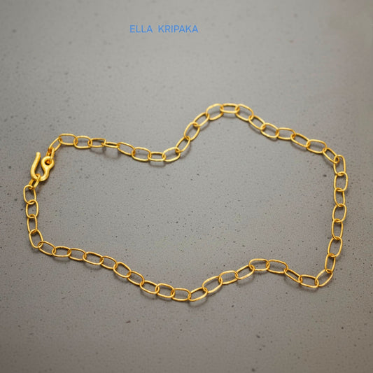 22k gold hammered chain necklace with thick hook clasp on grey concrete background, artist-jeweler's name 'Ella Kripaka' branding