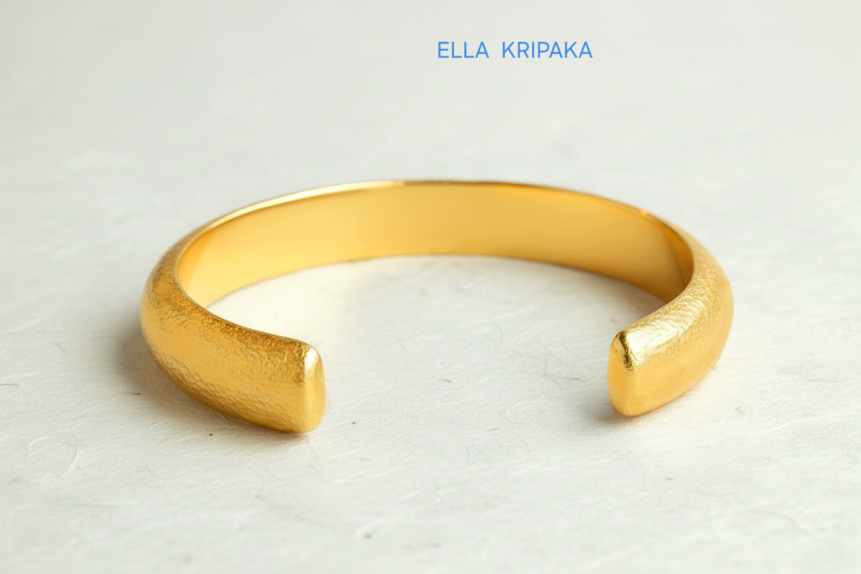 24k 9999 gold hammered cuff bracelet Ancient Rome style on a white craft paper  surface, artist-jeweler 'Ella Kripaka' branding