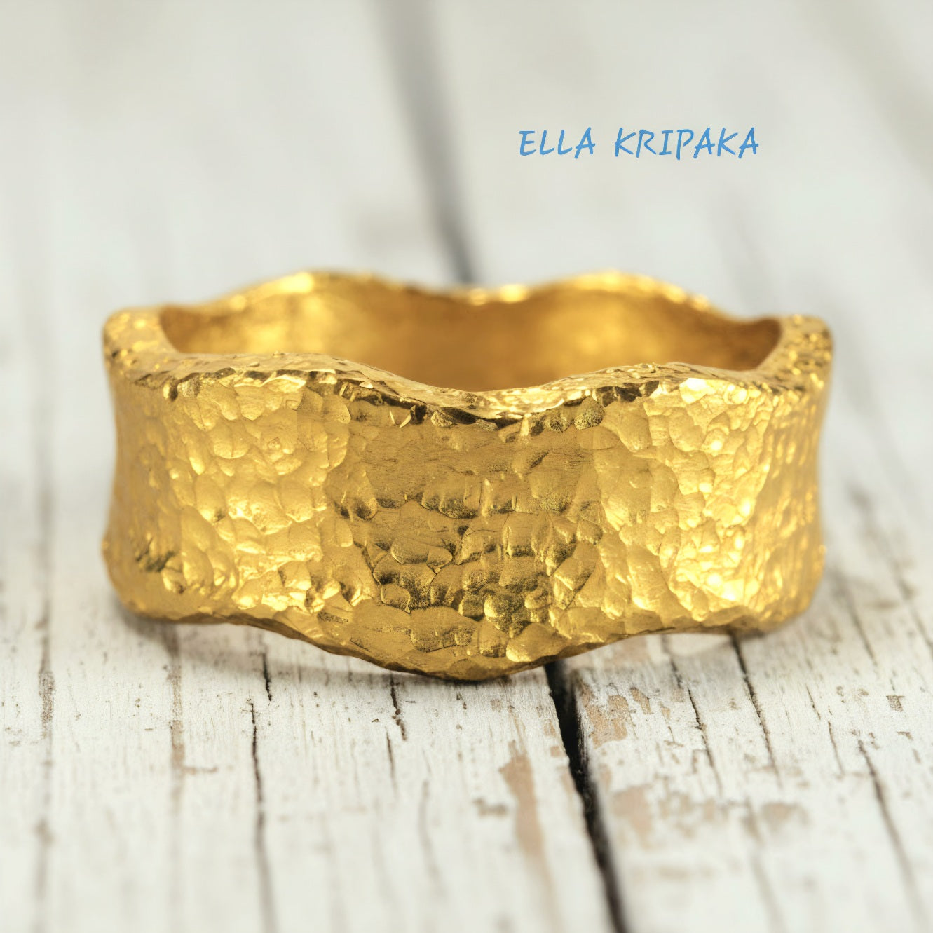 Hammered organic 24k Gold 9999 gold uneven wavy thick ring band with textured gold on a white old wooden background, branded 'Ella Kripaka'
