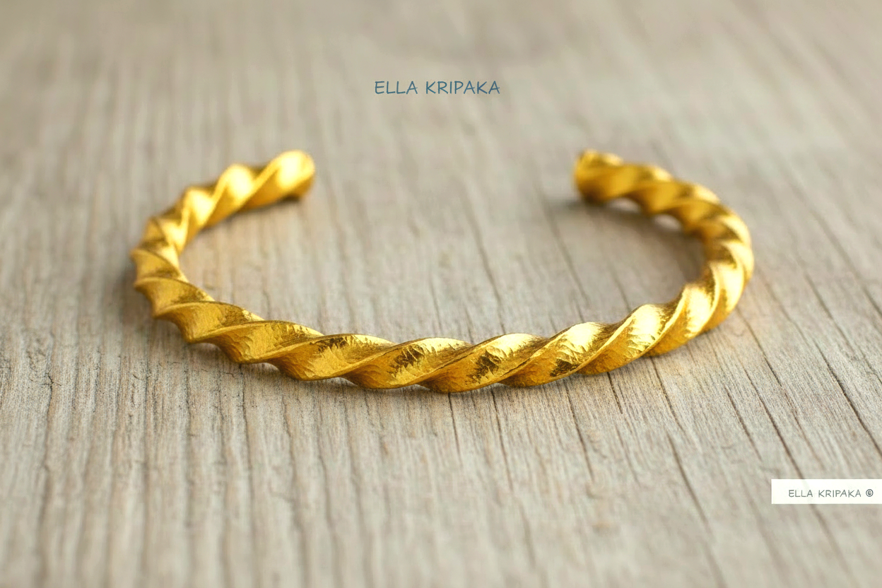 Viking twisted hammered 24k 9999 Gold thick cuff bracelet on a old wooden background, and with 'Ella Kripaka' branding