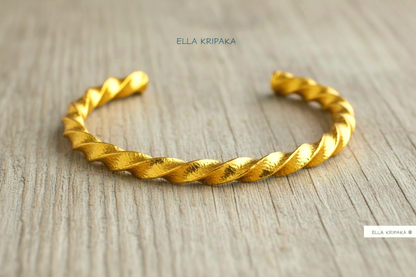 Viking twisted hammered 24k 9999 Gold thick cuff bracelet on a old wooden background, and with 'Ella Kripaka' branding