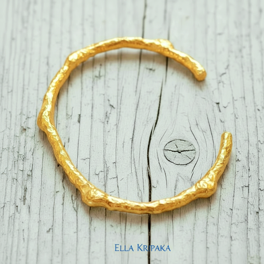 Organic hammered 24k 9999 gold bracelet uneven cuff on a old white wooden background, branding artist-jeweler name 'Ella Kripaka'