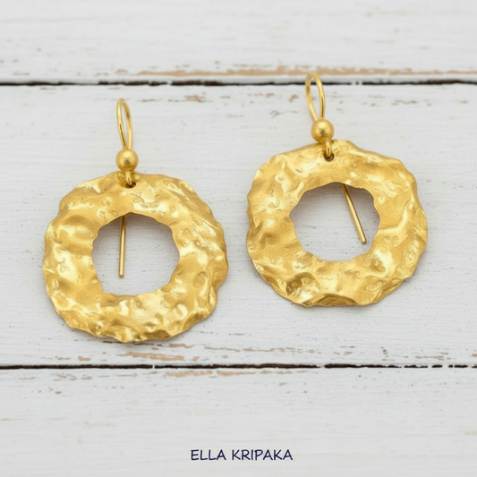 Organic 24k gold hammered wavy hoops earrings with shiny uneven gold textures on rustic wooden background, artist-jeweler 'Ella Kripaka' branding