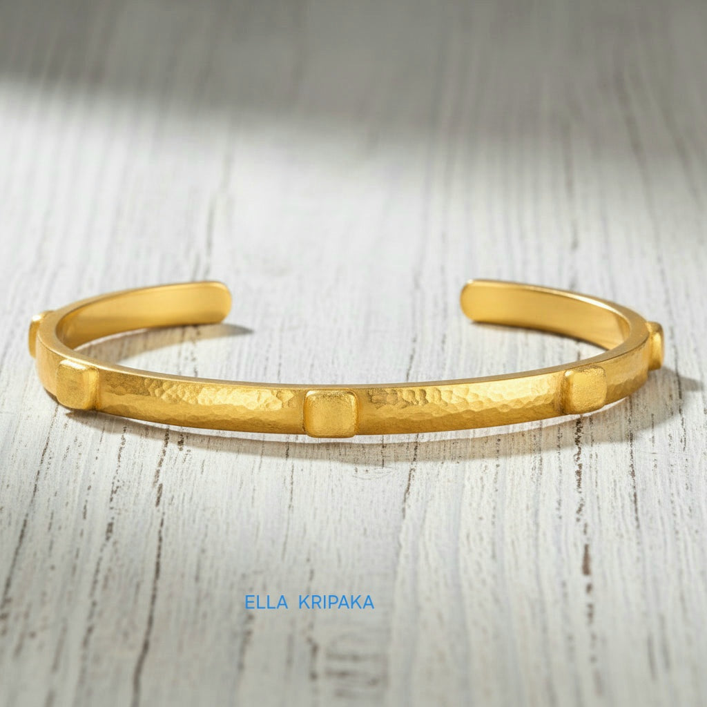 24k gold hammered cuff textured bracelet with thick squares on light rustic wooden surface, artist 'Ella Kripaka' branding