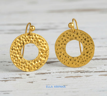 Organic 24k 9999 gold hammered hoops earrings with shiny gold textures are on white old wooden background, artist-jeweler's name 'Ella Kripaka'