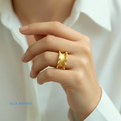 Hammered 24k 9999 Gold thick uneven wavy ring organic band on woman's finger and on a white shirt background, branded 'Ella Kripaka'