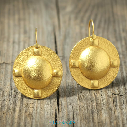Hammered 24k 9999 Gold Byzantine convex oval earrings on a old wooden background with 'Ella Kripaka' branding