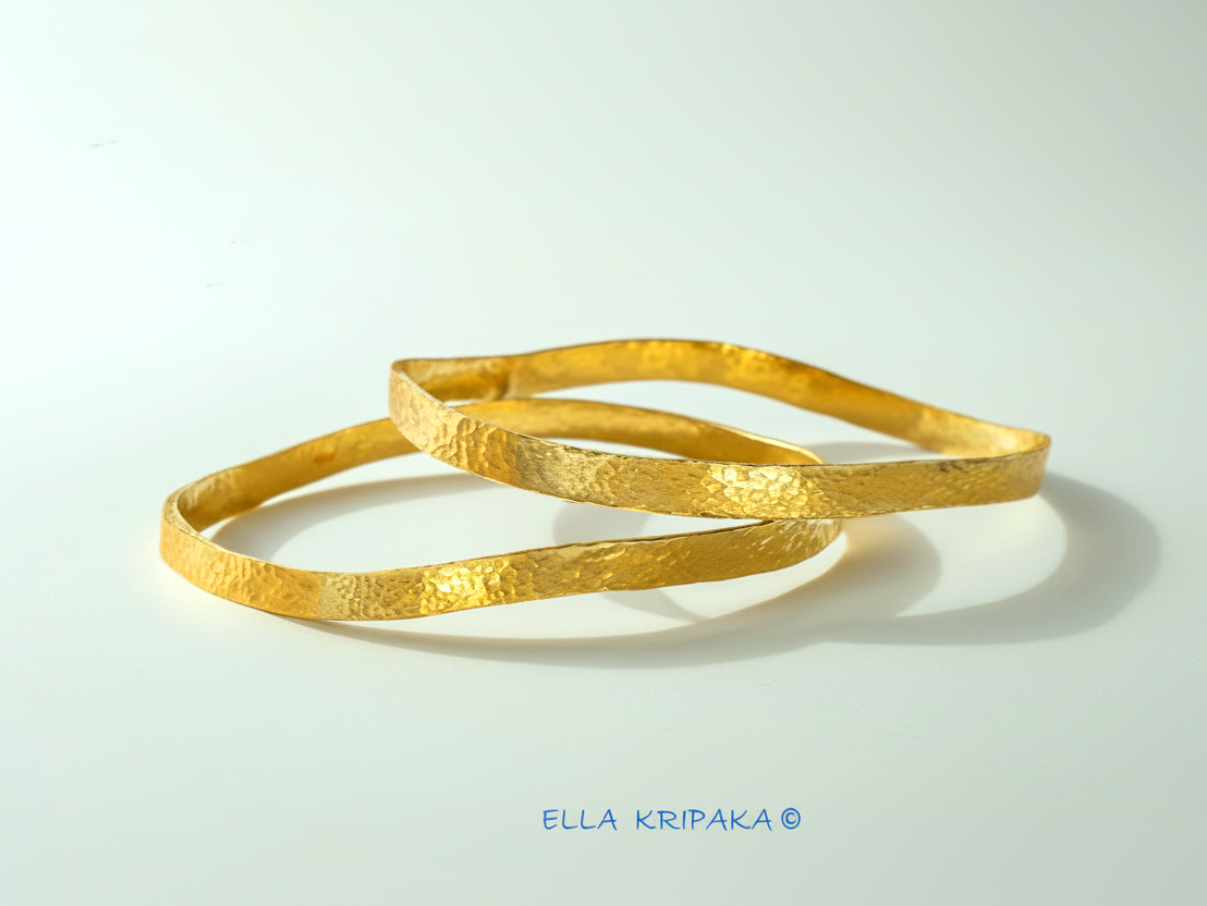 Uneven hammered 24k 9999 Gold organic two bangles bracelets on white surface, artist's name 'Ella Kripaka' branding