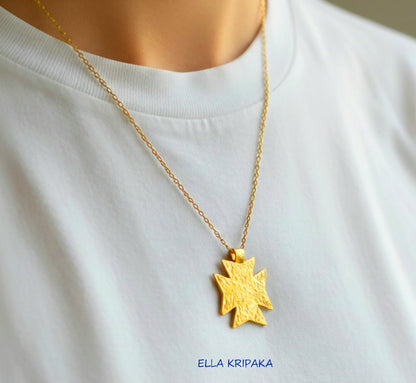 24k gold Byzantine cross pendant textured hammered with chain is worn by a model and with white t-shirt background, with 'Ella Kripaka' branding