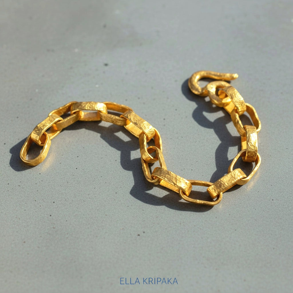 Hammered 24k 9999 gold chain thick bracelet with thick hook clasp Ancient Rome style on a grey background, artist-jeweler name 'Ella Kripaka' branding