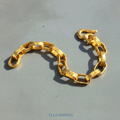 Hammered 24k 9999 gold chain thick bracelet with thick hook clasp Ancient Rome style on a grey background, artist-jeweler name 'Ella Kripaka' branding