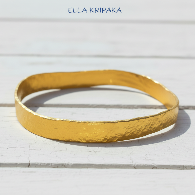 Organic 24k 9999 gold hammered uneven bangle thick bracelet on white wooden surface, artist-jeweler 'Ella Kripaka'