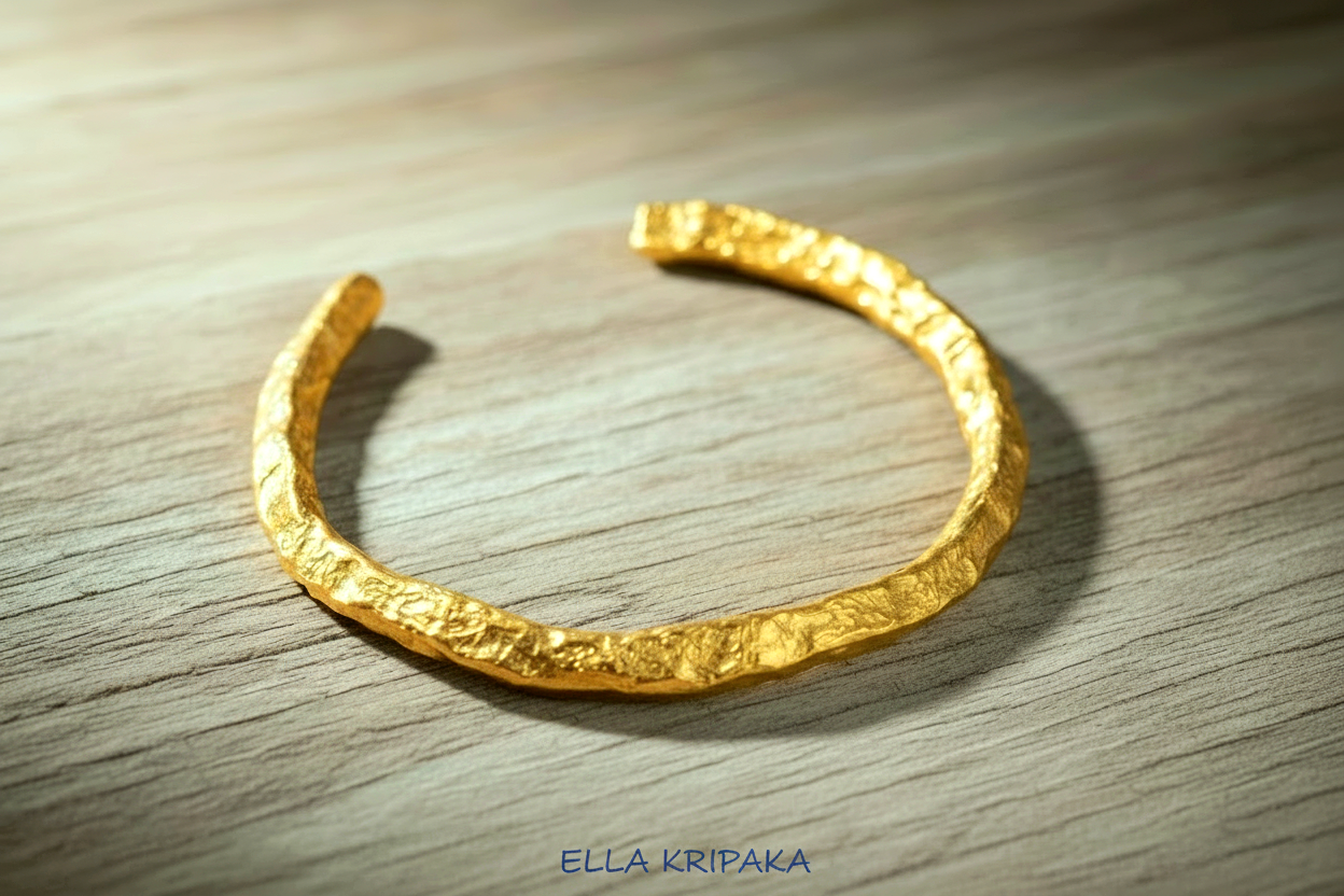 Organic hammered 24k 9999 Gold thick uneven cuff bracelet on a wooden background with 'Ella Kripaka' branding