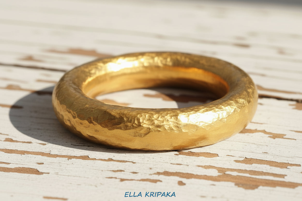Hammered 24k 9999 Gold ring thick Ancient Rome style on old white wooden surface, artist-jeweler's name 'Ella Kripaka' branding