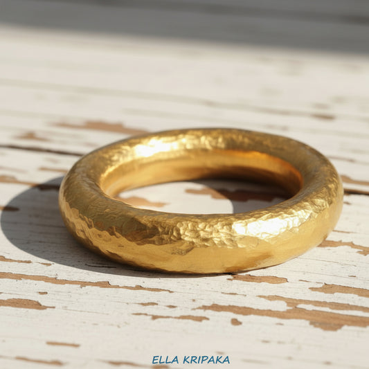 Hammered 24k 9999 Gold ring thick Ancient Rome style on old white wooden surface, artist-jeweler's name 'Ella Kripaka' branding