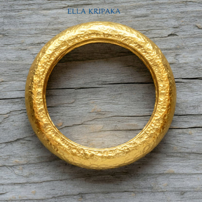 Hammered 24k Gold 9999 gold Ancient Rome  thick ring with textured forged gold on a grey old wooden background, branded 'Ella Kripaka'