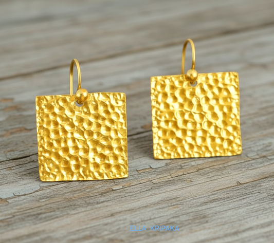 Organic 24k gold hammered textured square earrings on old wooden surface, artist 'Ella Kripaka' branding
