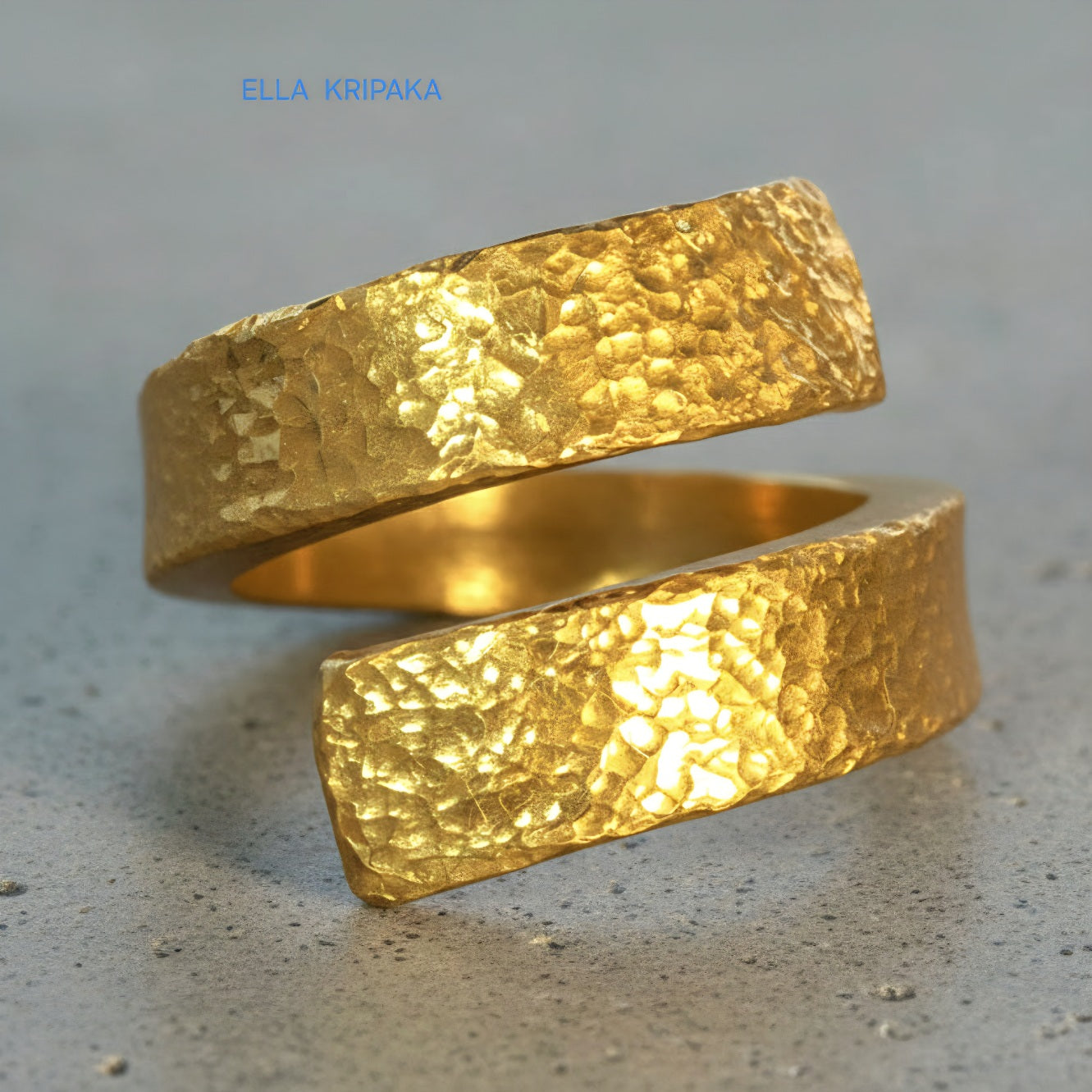 Hammered twisted 24k Gold 9999 gold signet thick ring with textured gold on a grey concrete background, branded 'Ella Kripaka'