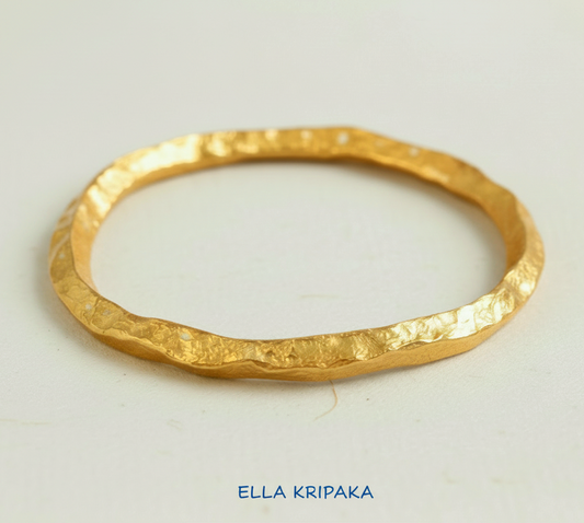 Organic hammered 24k Gold thick bangle uneven bracelet on neutral background, artist's name 'Ella Kripaka' branding