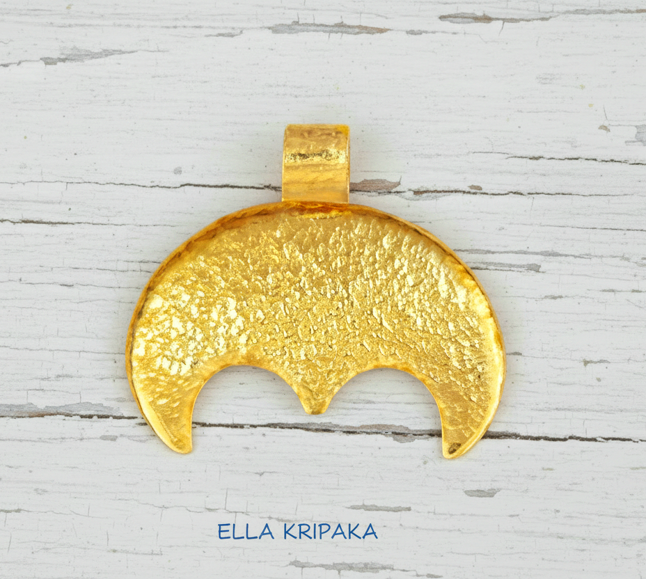 Hammered 24k gold convex Moon pendant on a white rustic wooden background with 'Ella Kripaka' branding