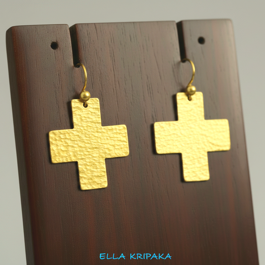 Hammered 24k 9999 Gold Byzantine cross earrings on a jewelry wooden stand with 'Ella Kripaka' branding
