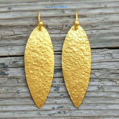 Hammered 24k 9999 Gold Byzantine leaf earrings on a old wooden background with 'Ella Kripaka' branding