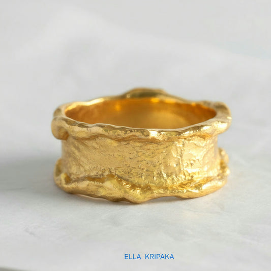 Organic 24k gold hammered ring with textured surface and uneven edges on a white craft  paper background, branded 'Ella Kripaka'