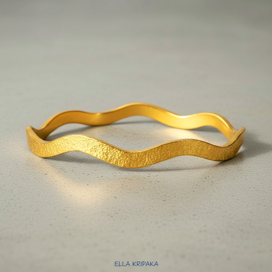 24k gold hammered bracelet textured bangle with wavy design on grey concrete background, branded 'Ella Kripaka'