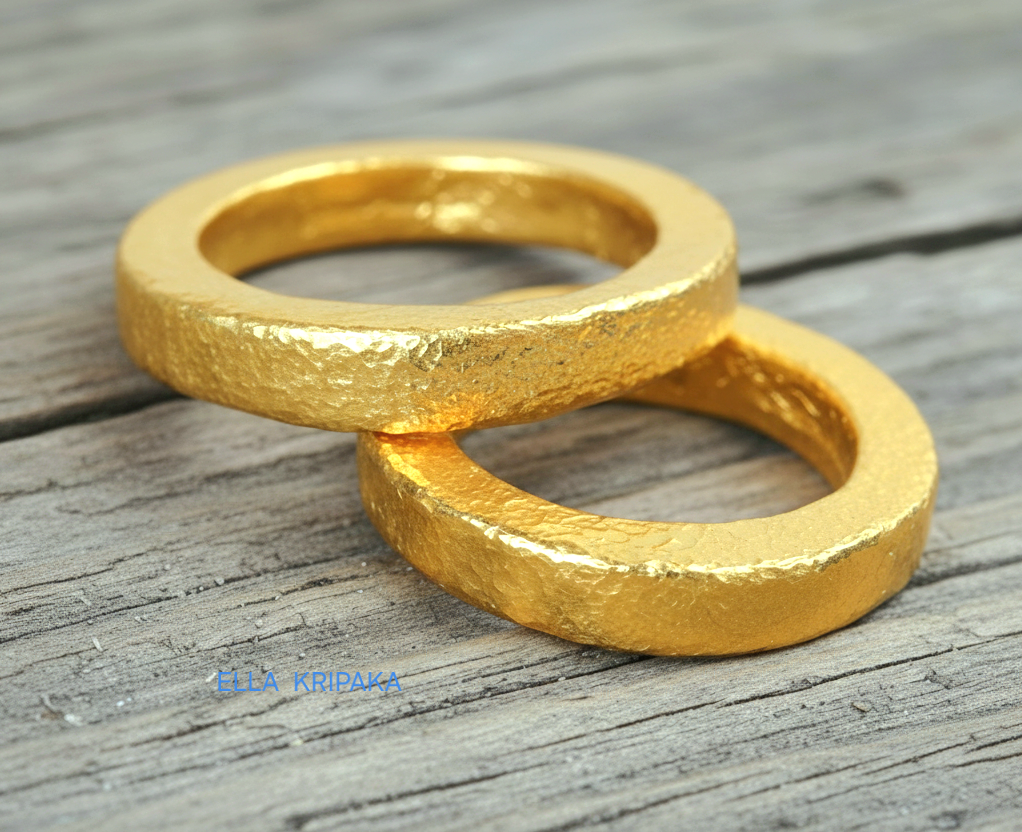 Hammered 24k Gold 9999 gold Ancient Rome  thick two rings with textured forged gold on a grey old wooden background, branded artist-jeweler's name 'Ella Kripaka'
