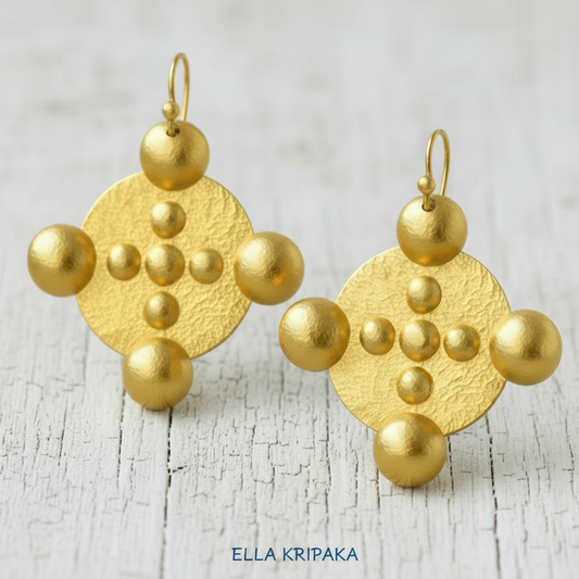 Hammered 24k gold, pure 9999 gold Byzantine convex rounds earrings with shiny forged gold textures on old wooden surface, artist-jeweler 'Ella Kripaka' branding