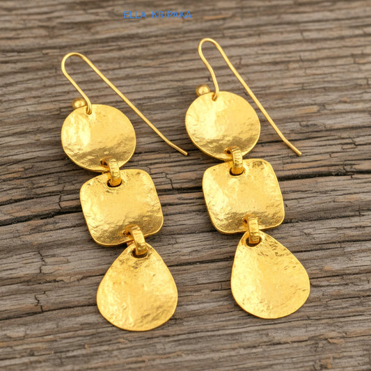 Solid 24k 9999 gold hammered Byzantine earrings with hook clasps and shiny forged gold textures on old wooden background , artist's name 'ELLA KRIPAKA'