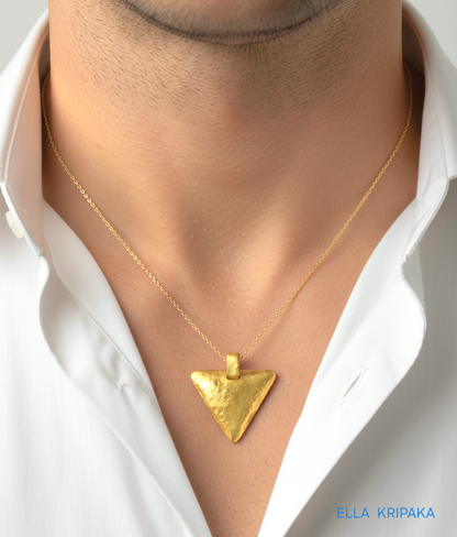 Hammered 24k gold convex triangle pendant with chain worn by a person and with a white shirt background with 'Ella Kripaka' branding