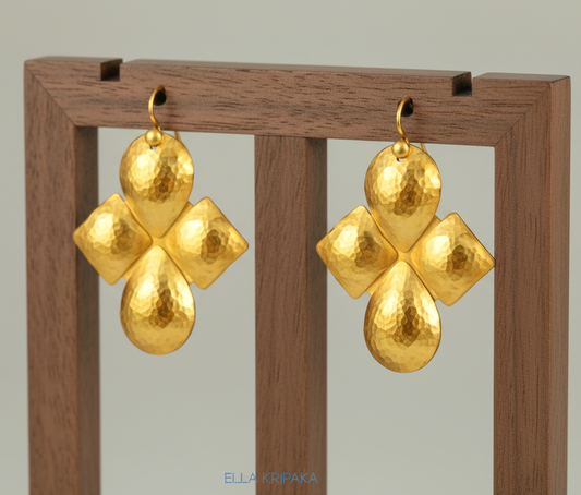 Hammered 24k 9999 Gold Byzantine cross convex earrings on a jewelry wooden stand with 'Ella Kripaka' branding