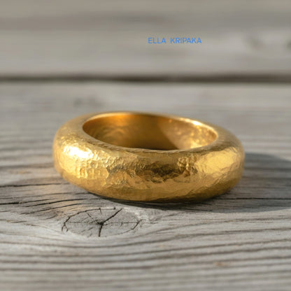 Hammered 24k Gold 9999 gold Ancient Rome  thick ring with textured forged gold on a grey old wooden background, branded artist-jeweler's name 'Ella Kripaka'