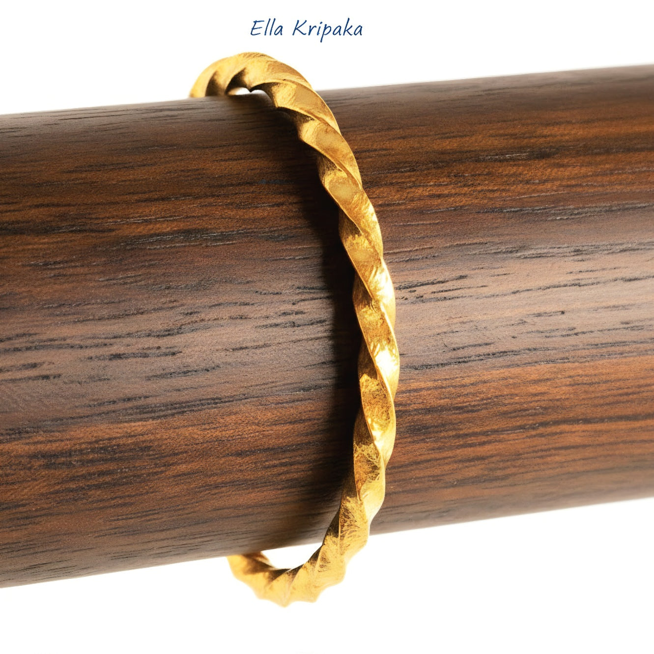 Twisted Viking Hammered 24k 9999 Gold bangle bracelet on wooden stand, artist's name 'Ella Kripaka' branding