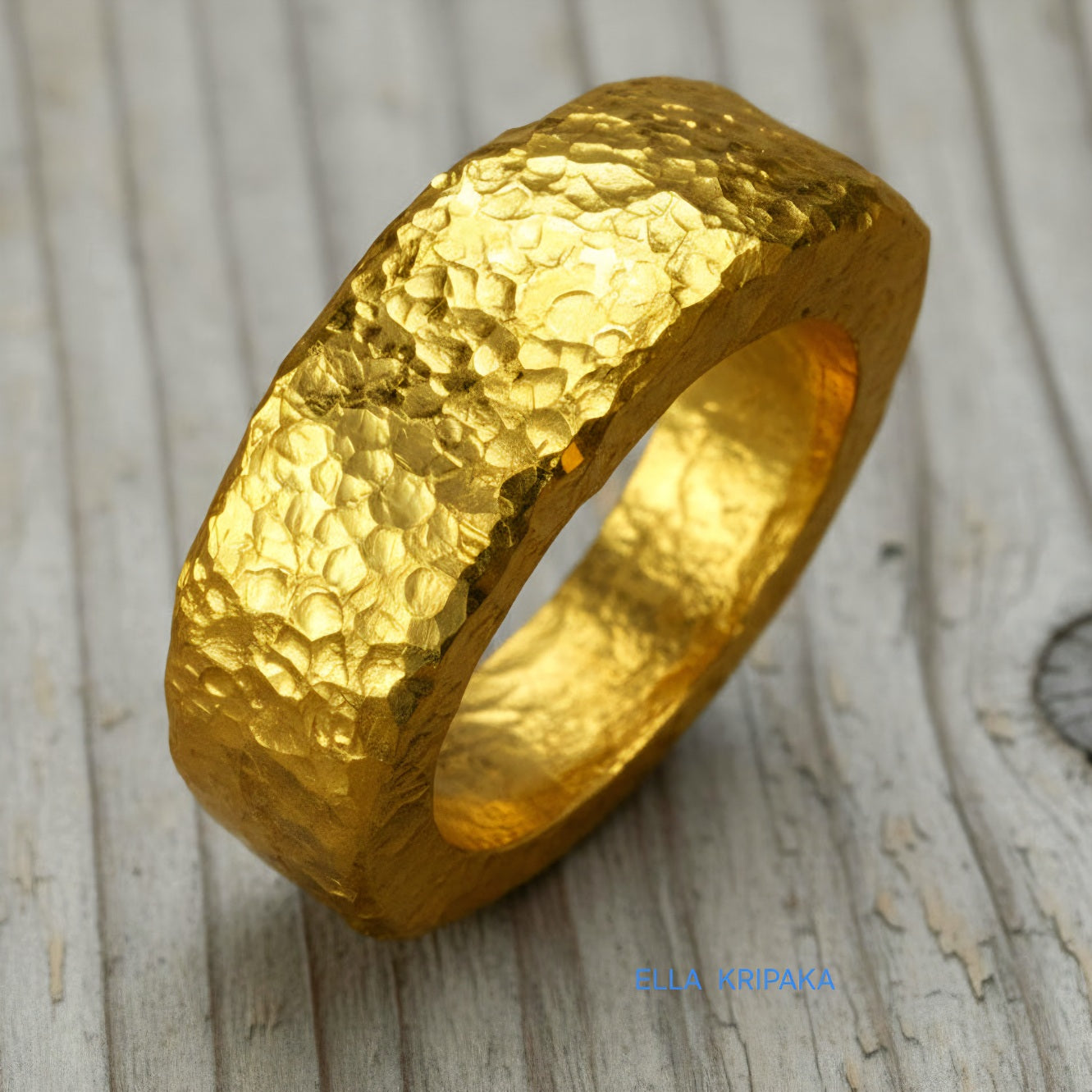 Hammered 24k 9999 Gold thick ring Ancient Rome style with a textured forged gold surface on a old wooden background, branded 'Ella Kripaka'