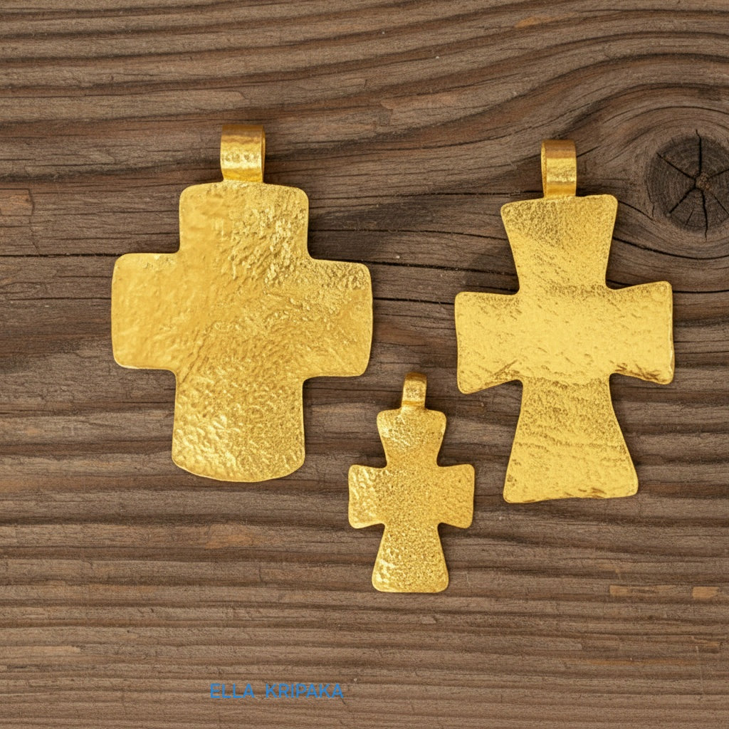 Three hammered 24k gold textured cross pendant on rustic old wooden surface, creator artist-jeweler 'Ella Kripaka' branding