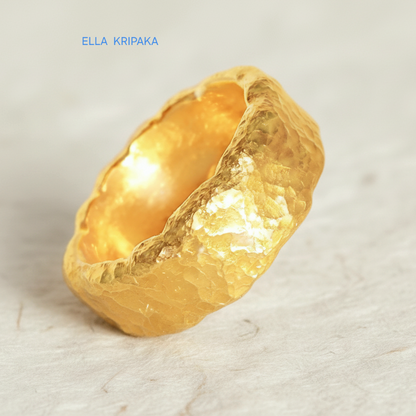 Hammered organic 24k Gold 9999 gold uneven wavy thick ring band with textured gold on a white craft paper background, branded 'Ella Kripaka'