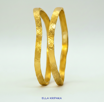Uneven hammered 24k 9999 Gold organic two bangles bracelets on white surface, artist's name 'Ella Kripaka' branding
