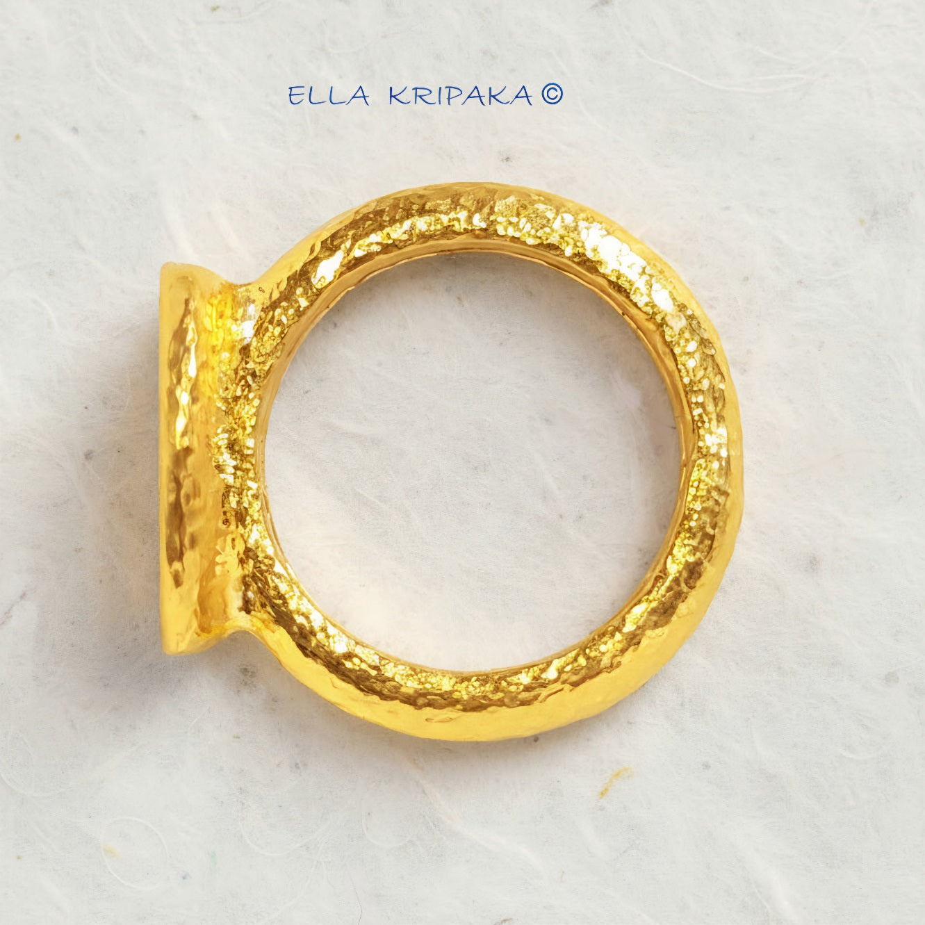 Hammered 24k 9999 Gold thick ring signet Ancient Rome style with a textured forged gold surface on a white craft paper background, branded 'Ella Kripaka'