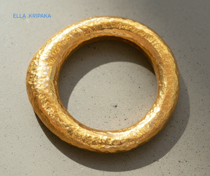 Hammered organic 24k Gold 9999 gold signet thick ring band with textured gold on a grey concrete background, branded 'Ella Kripaka'