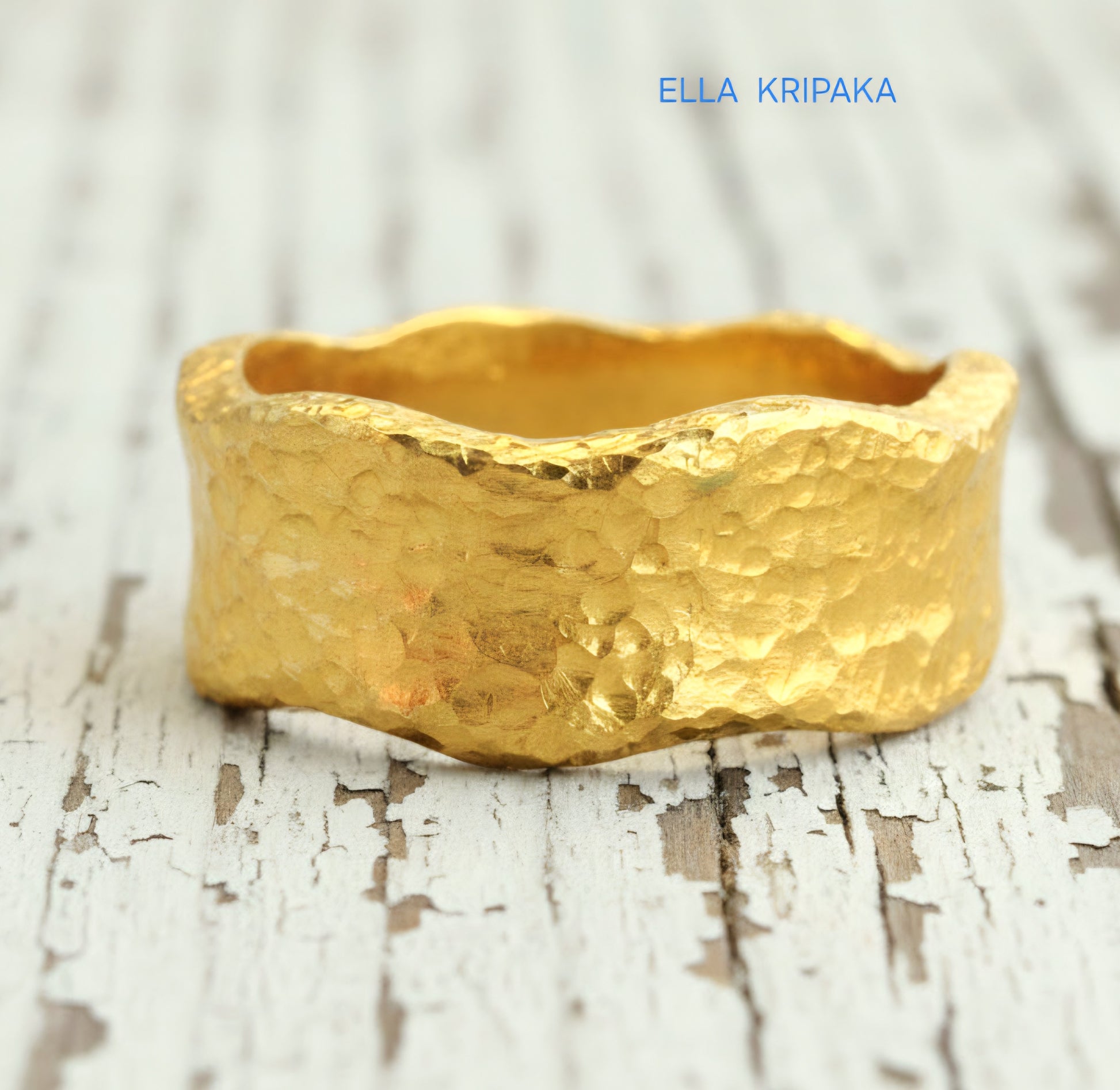 Hammered organic 24k Gold 9999 gold uneven wavy thick ring band with textured gold on a white old wooden background, branded 'Ella Kripaka'