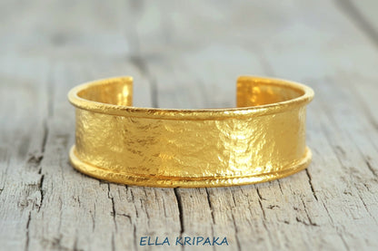 Hammered 24k 9999 gold bracelet cuff Ancient Rome style on a old wooden background, branding artist-jeweler name 'Ella Kripaka'
